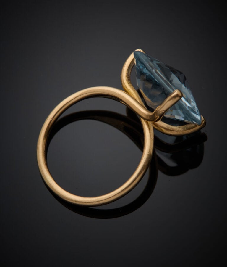 BAGUE en or jaune (750‰) serti d'une topaze bleue ronde de taille fantaisie. -…