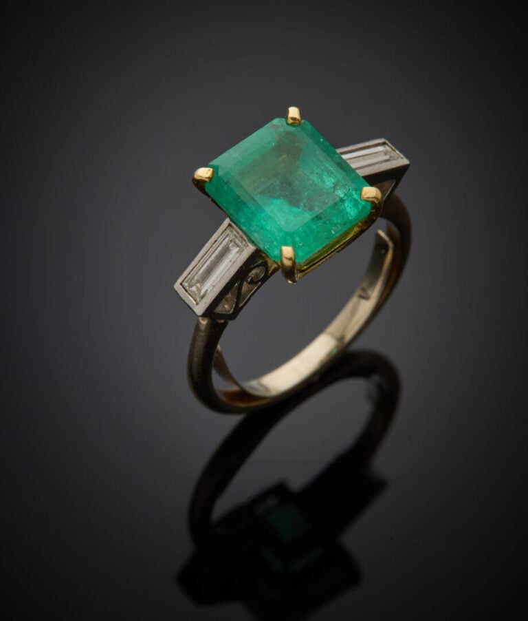 BAGUE en or jaune et or gris (750‰) serti d'une émeraude rectangulaire taillée…