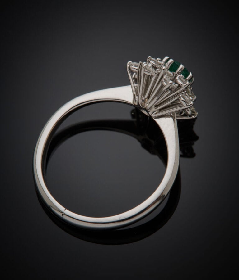 BAGUE "fleur" en or gris (750‰) serti d'une émeraude ronde, entourée de seize d…