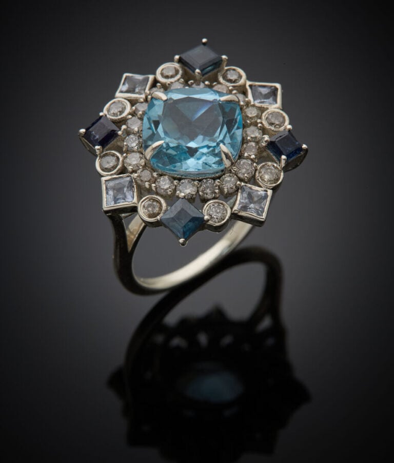 BAGUE "flocon" en argent (925‰) ajouré serti d'une topaze bleue de forme coussi…