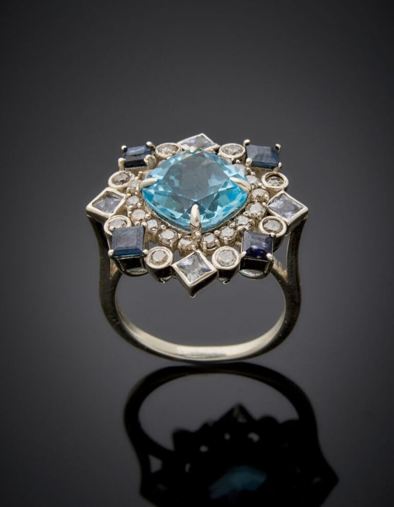 BAGUE "flocon" en argent (925‰) ajouré serti d'une topaze bleue de forme coussi…