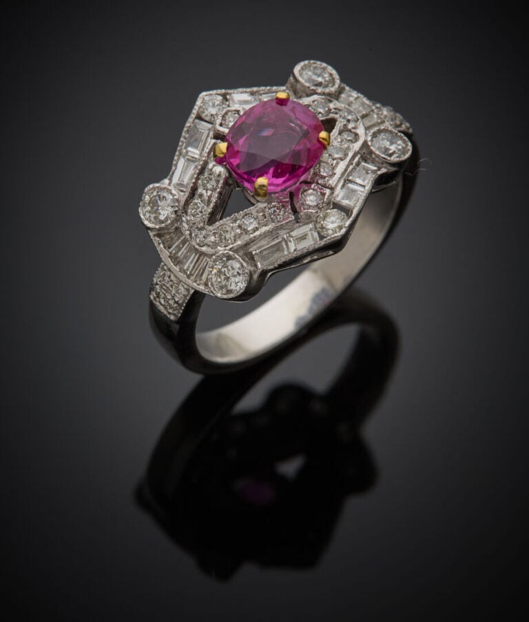 BAGUE géométrique en or gris (750‰) ajouré, sertie d'un rubis rond, entouré de…