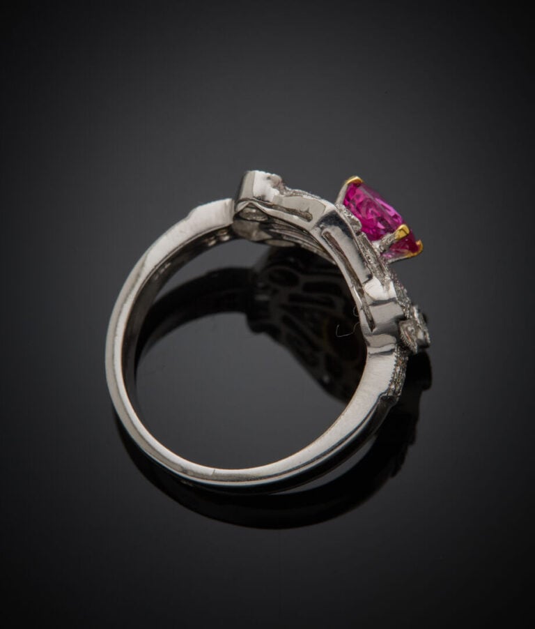 BAGUE géométrique en or gris (750‰) ajouré, sertie d'un rubis rond, entouré de…