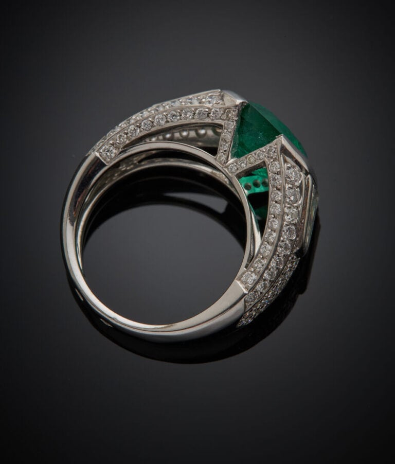 BAGUE "jonc" en or gris (750‰) ajouré surmontée d'une émeraude ronde épaulée de…