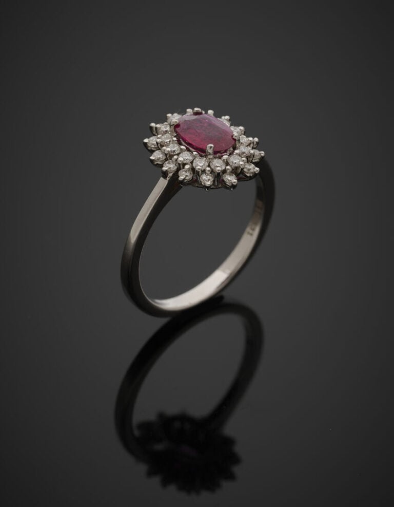BAGUE "marguerite" en or gris (750‰) serti d'un rubis de forme ovale, entouré d…