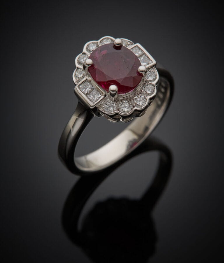 BAGUE "marguerite" en or gris (750‰) serti d'un rubis ovale pesant 1,14 carat,…