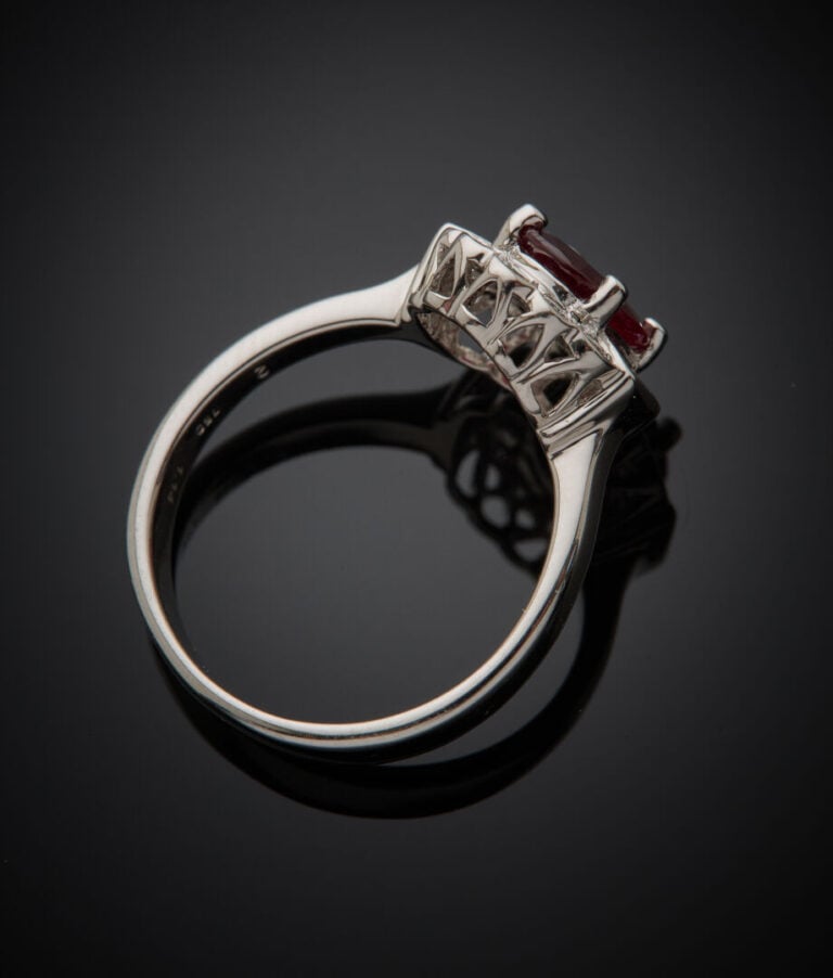 BAGUE "marguerite" en or gris (750‰) serti d'un rubis ovale pesant 1,14 carat,…