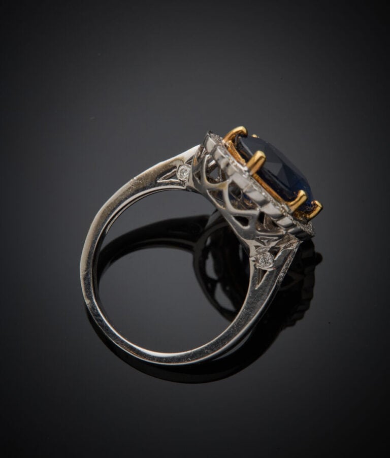 BAGUE "marguerite" en or gris et or jaune (750‰) serti d'un saphir ovale, entou…