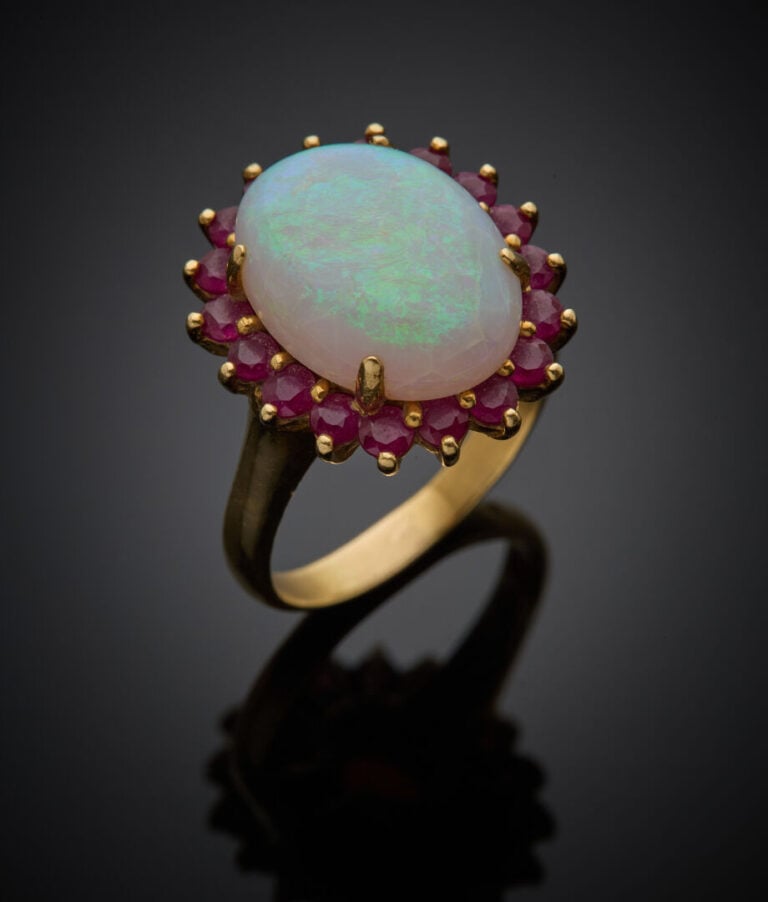BAGUE "marguerite" en or jaune (750‰) orné d'une opale de forme ovale (fêles),…