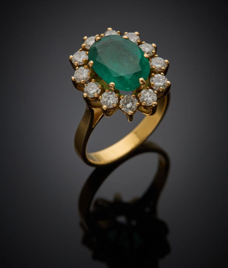 BAGUE "marguerite" en or jaune (750‰) serti d'une émeraude de forme ovale entou…