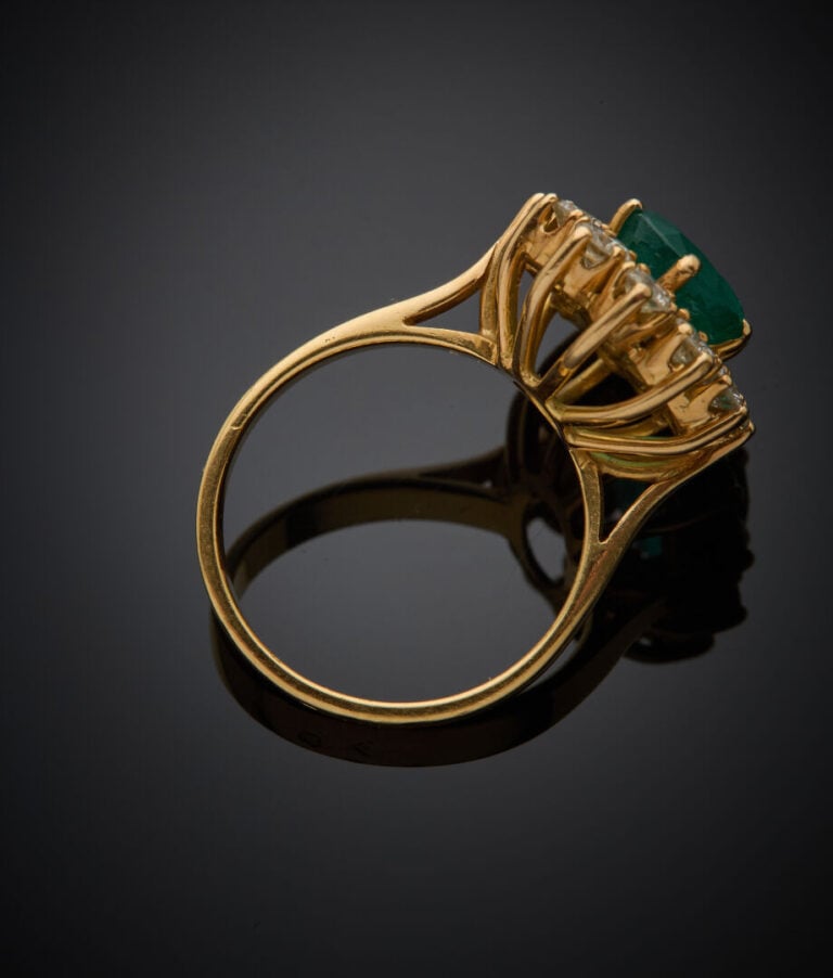 BAGUE "marguerite" en or jaune (750‰) serti d'une émeraude de forme ovale entou…