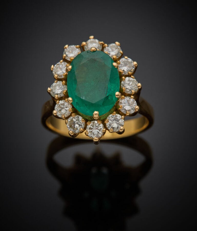 BAGUE "marguerite" en or jaune (750‰) serti d'une émeraude de forme ovale entou…