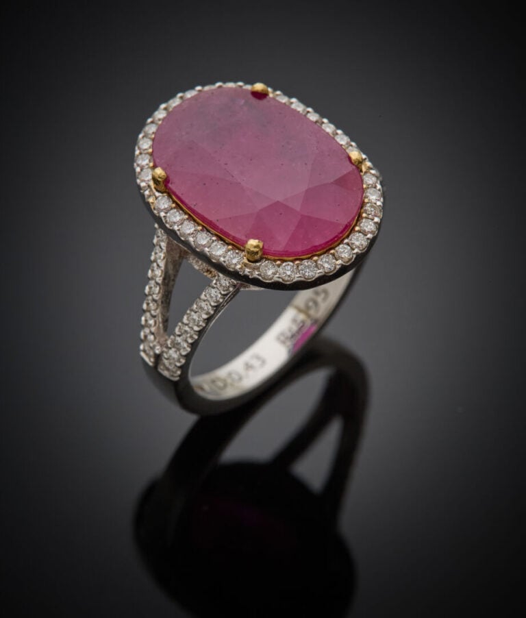 BAGUE ovale en or gris (750‰) ajouré, serti d'un rubis ovale pesant 5,95 carats…