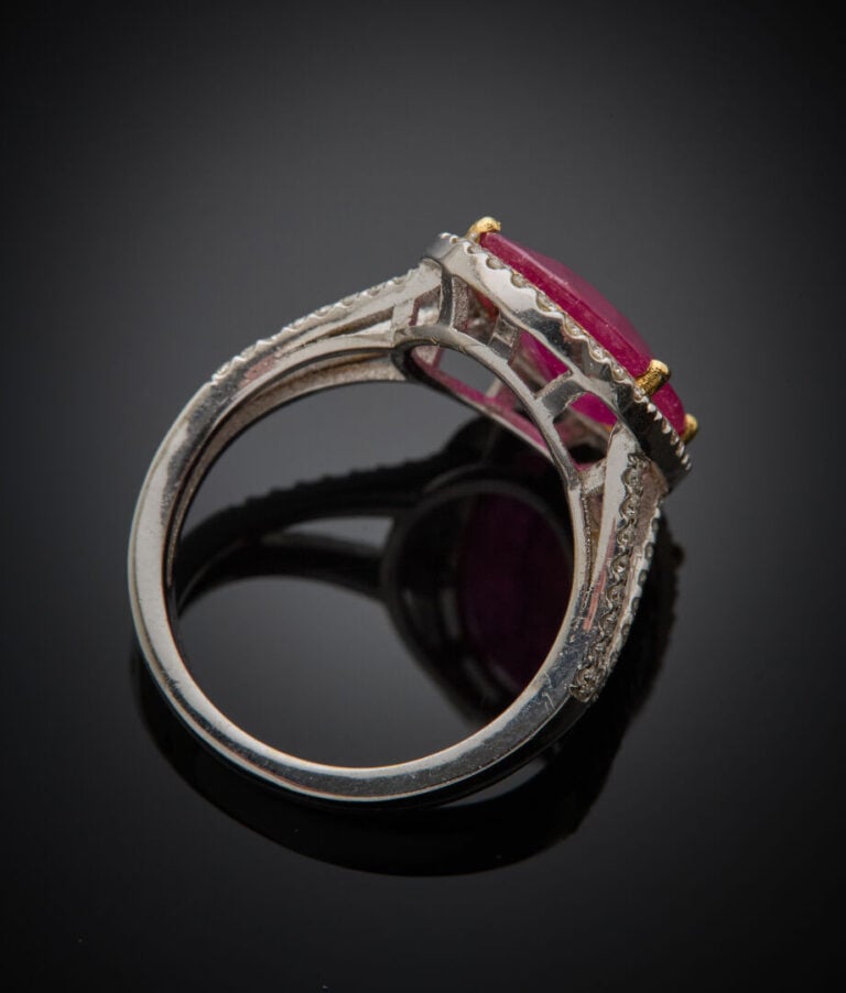 BAGUE ovale en or gris (750‰) ajouré, serti d'un rubis ovale pesant 5,95 carats…