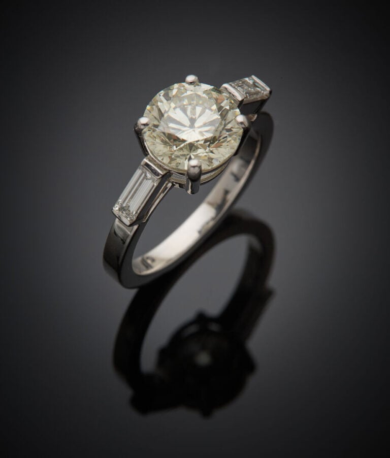 BAGUE solitaire en or gris (750‰) serti d'un diamant taille brillant épaulé de…