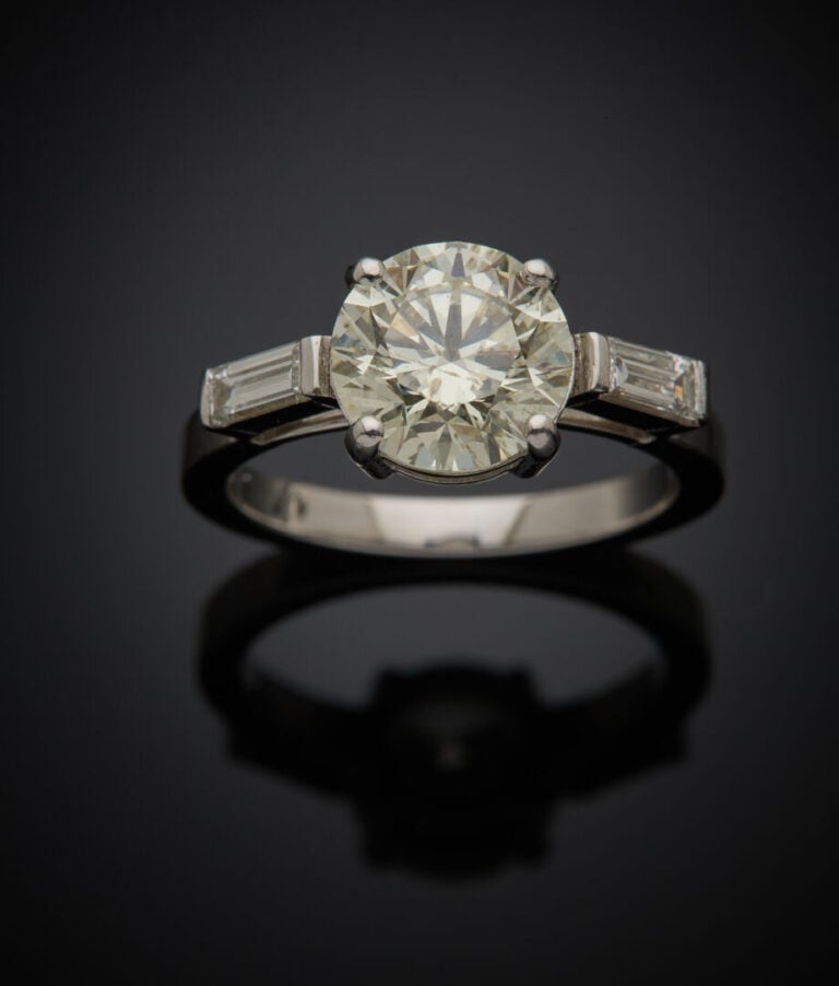 BAGUE solitaire en or gris (750‰) serti d'un diamant taille brillant épaulé de…