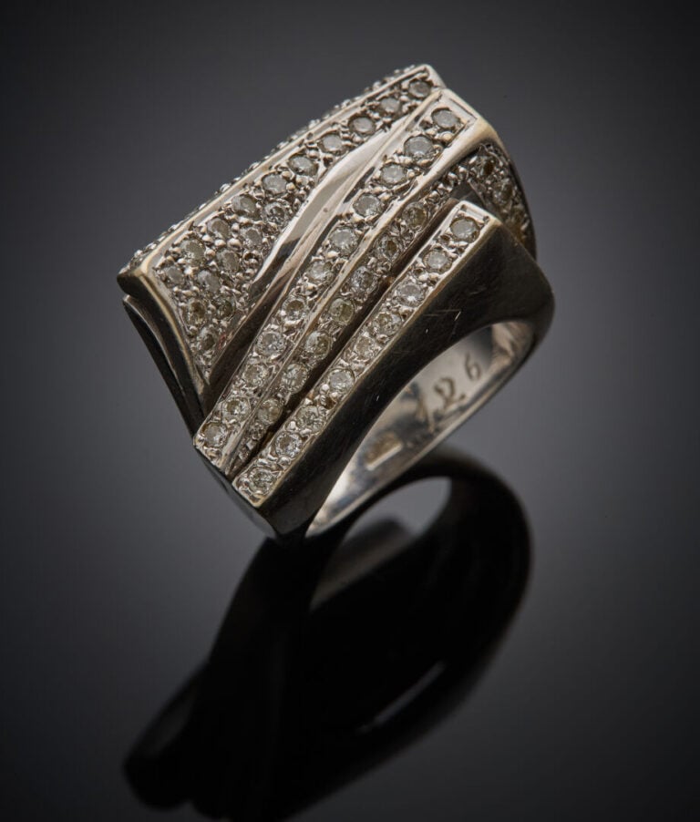 BAGUE stylisée "feuilletée et courbée" en or gris (750‰) serti d'alignements de…