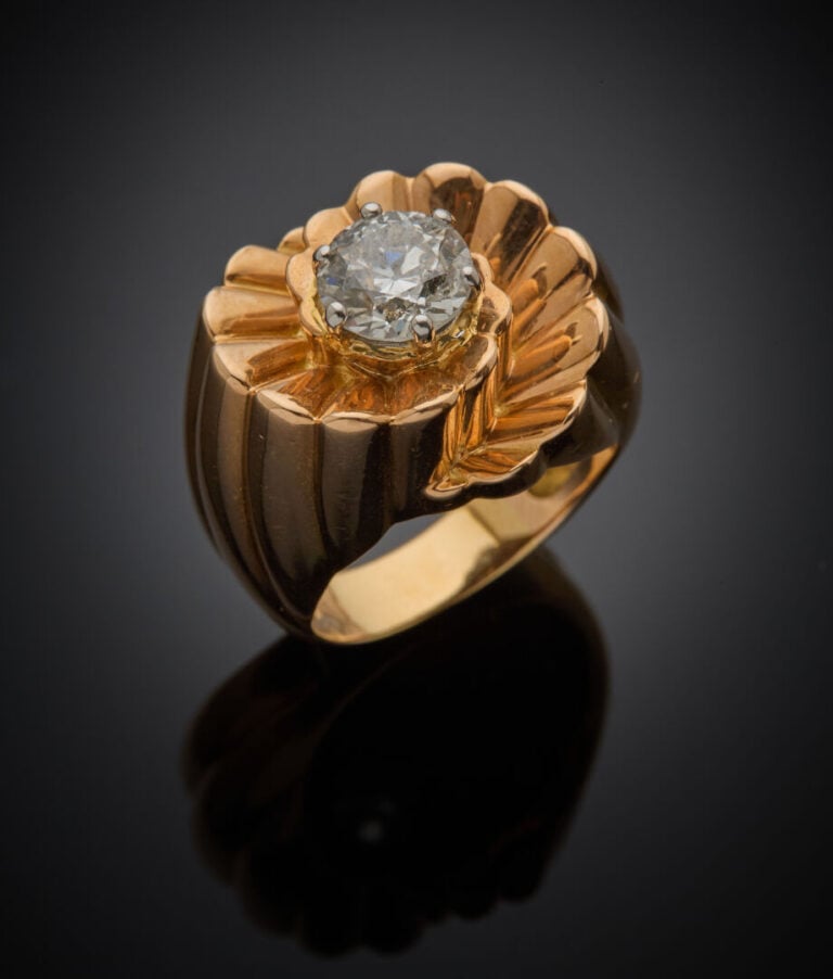 BAGUE "volutes" en or jaune (750‰) entièrement godronné, centrée d'un diamant t…