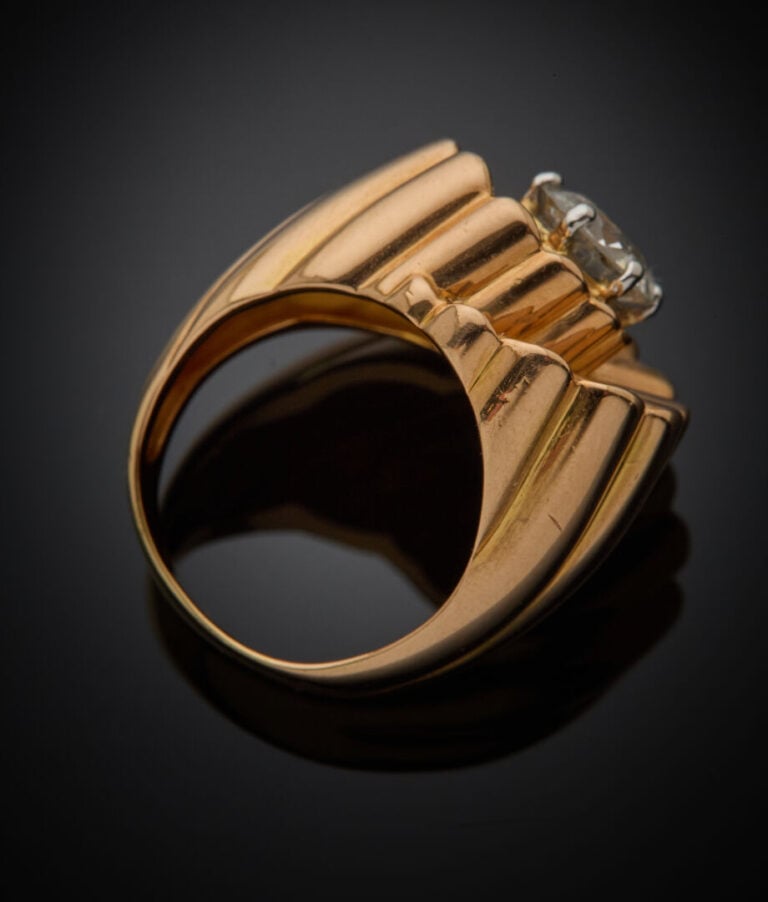 BAGUE "volutes" en or jaune (750‰) entièrement godronné, centrée d'un diamant t…