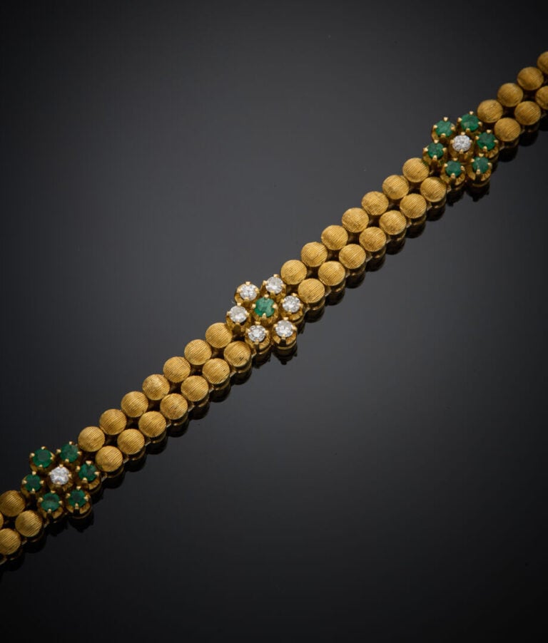 BRACELET articulé en or jaune (750‰) à motifs de pastilles guillochées, flanqué…