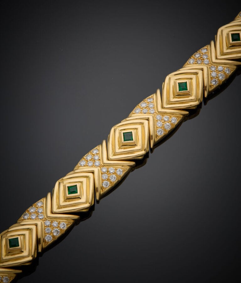 BRACELET articulé géométrique en or jaune (750‰) godronné, serti de neuf émerau…