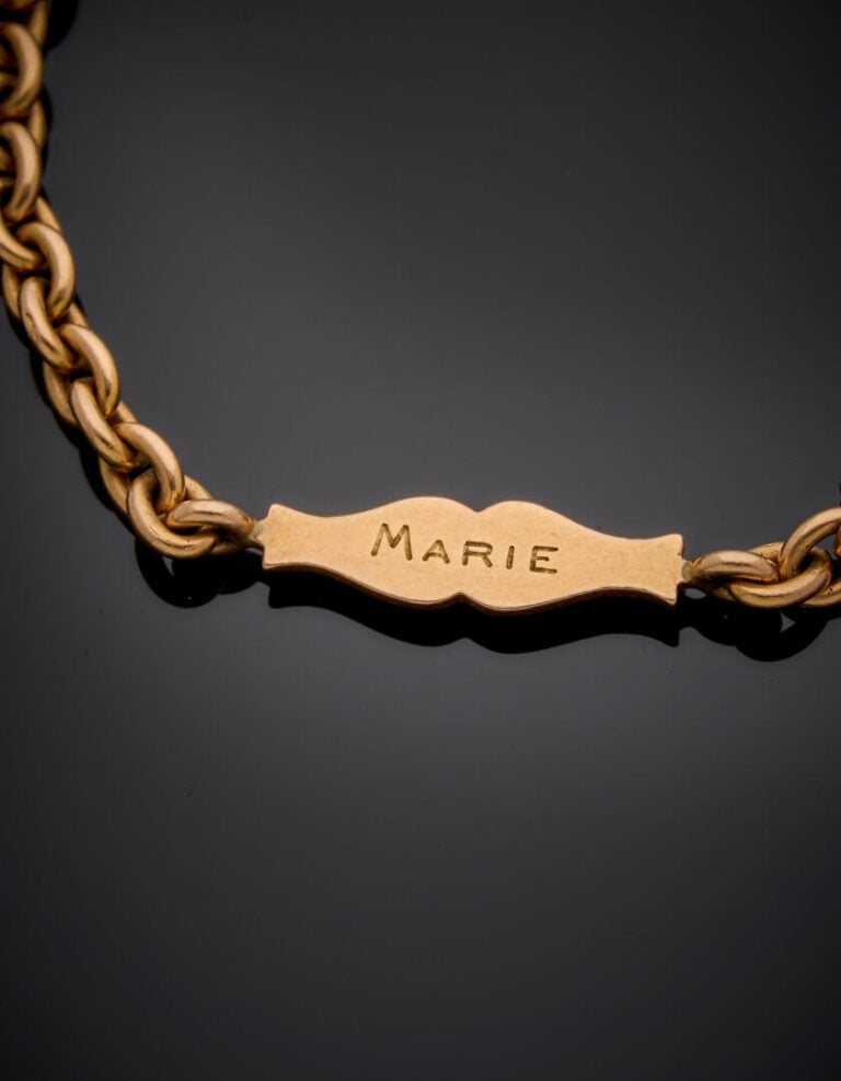 BRACELET en or rose (750‰) retenant une plaque gravée "Marie" et datée 1903. -…