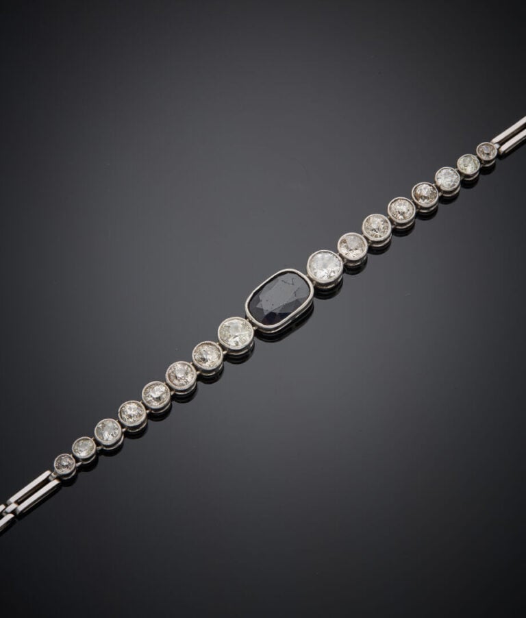 BRACELET en platine (min. 800‰) et or gris (750‰) articulé et ajouré, centré d'…