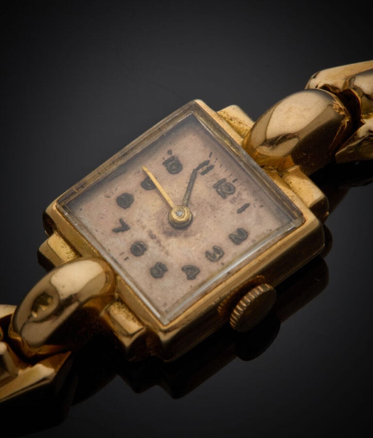 BRACELET MONTRE carrée de dame en or jaune (750‰). Cadran cuivré (taches), chif…