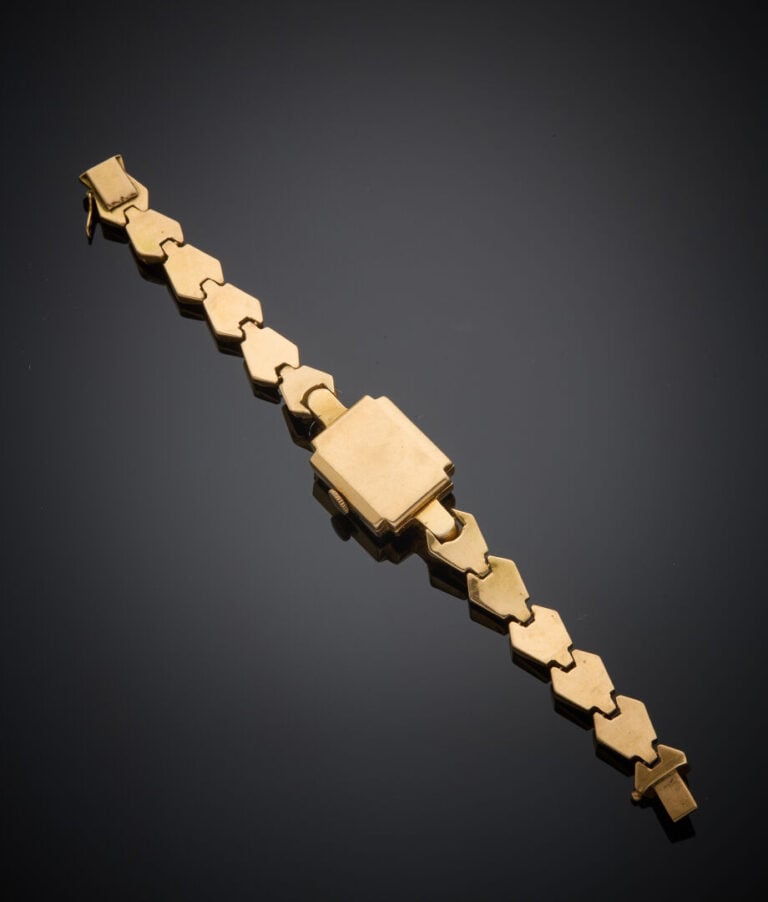 BRACELET MONTRE carrée de dame en or jaune (750‰). Cadran cuivré (taches), chif…