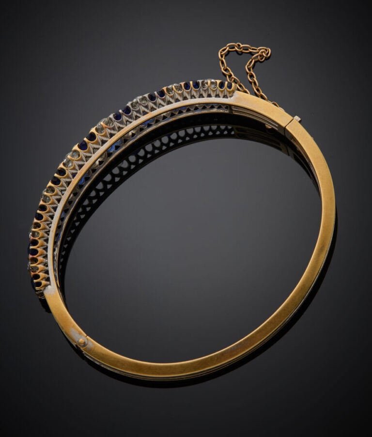 BRACELET rigide ouvrant en or jaune (750‰) ajouré, serti de deux alignements de…