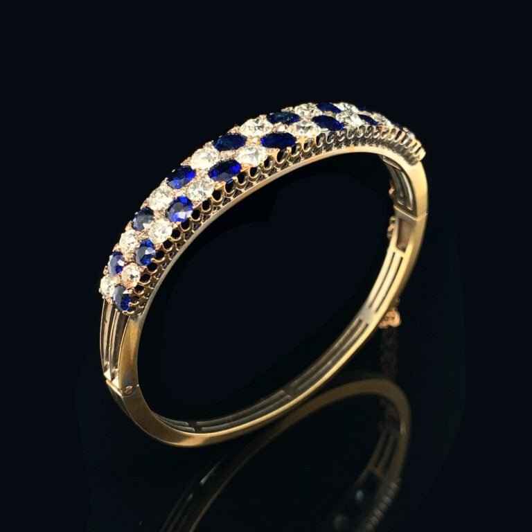 BRACELET rigide ouvrant en or jaune (750‰) ajouré, serti de deux alignements de…