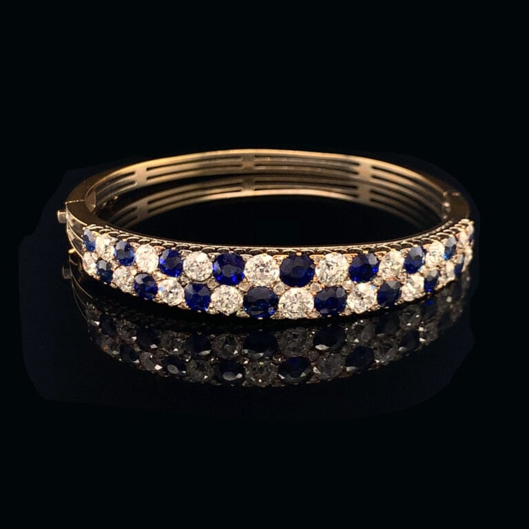 BRACELET rigide ouvrant en or jaune (750‰) ajouré, serti de deux alignements de…