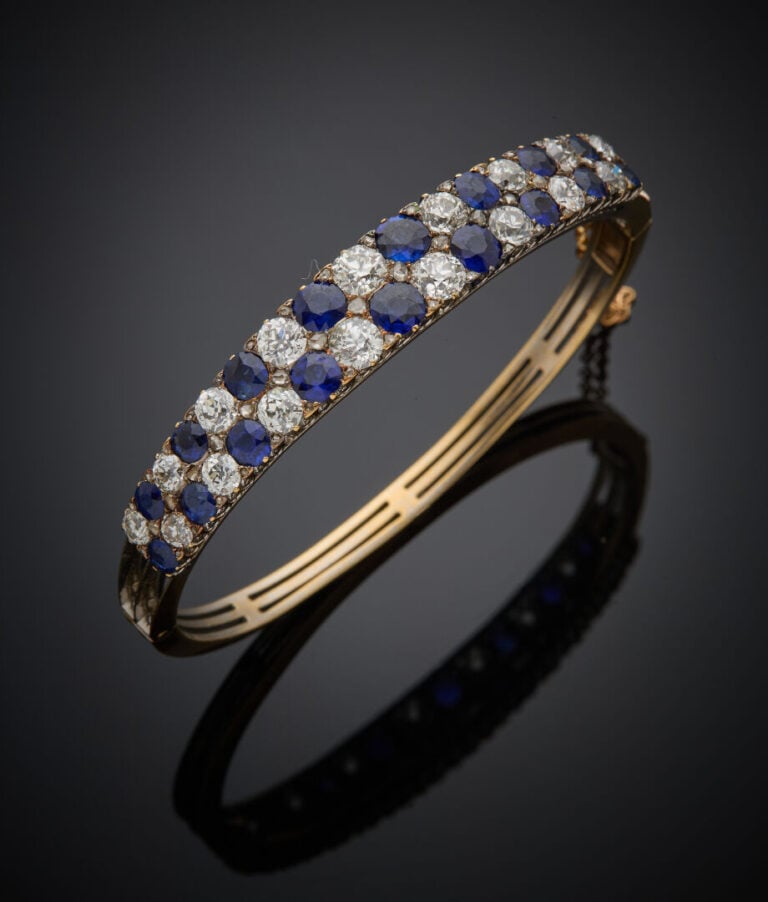BRACELET rigide ouvrant en or jaune (750‰) ajouré, serti de deux alignements de…