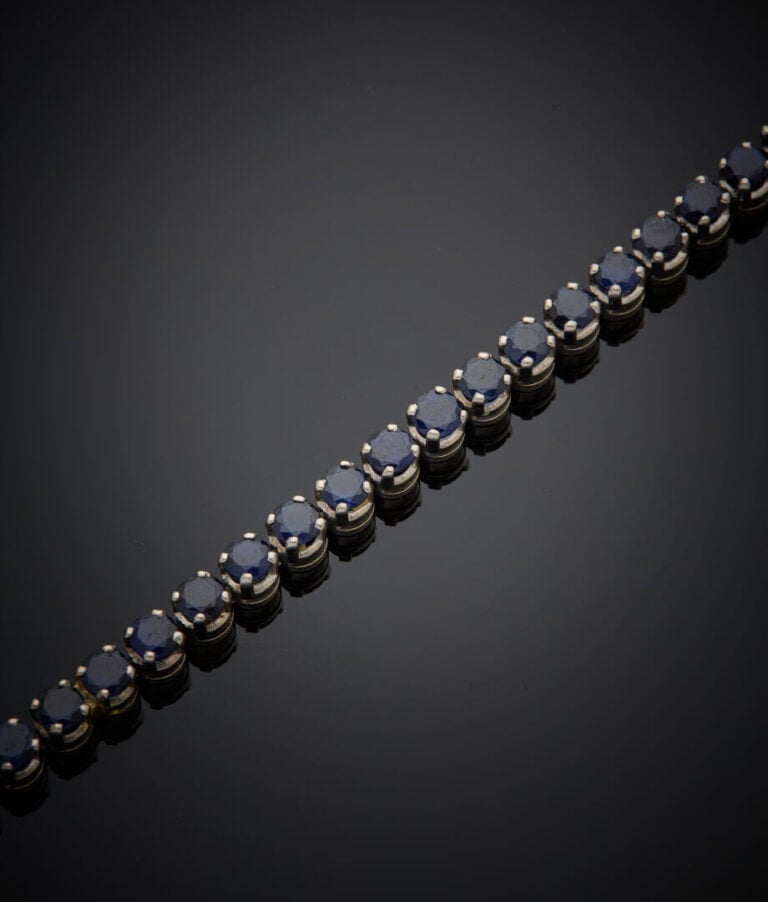 BRACELET "tennis" en or gris (750‰) serti d'un alignement de saphirs ronds (égr…