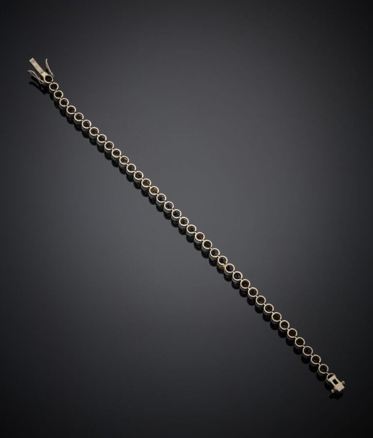 BRACELET "tennis" en or gris (750‰) serti d'un alignement de saphirs ronds (égr…