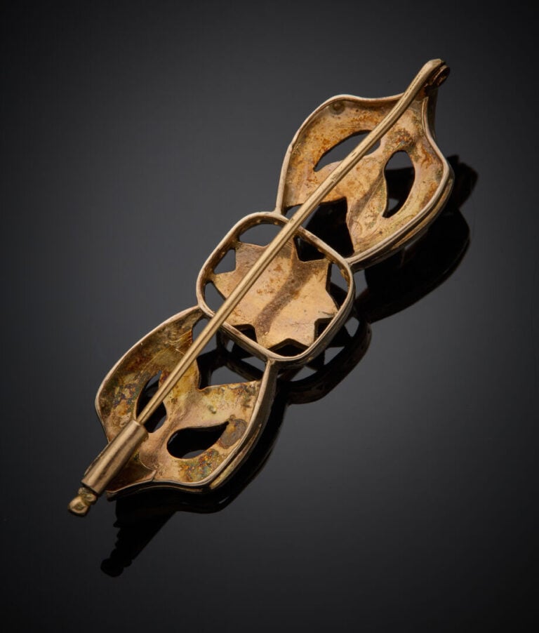 BROCHE "nœud" en or jaune (585‰) 14 carats et argent (min. 800‰) ajouré, serti…