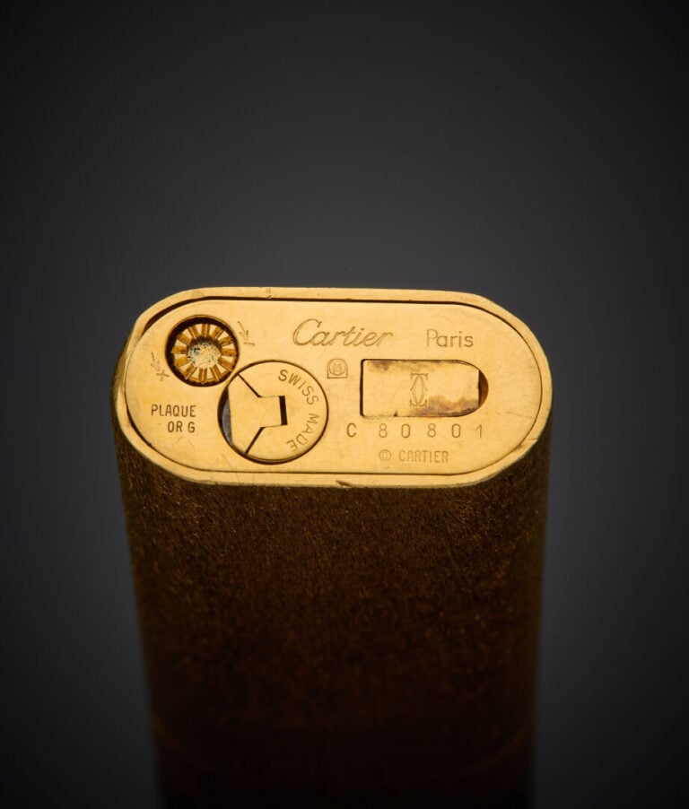 CARTIER - - Deux BRIQUETS en métal doré, l'un orné de laque rose, l'autre entiè…