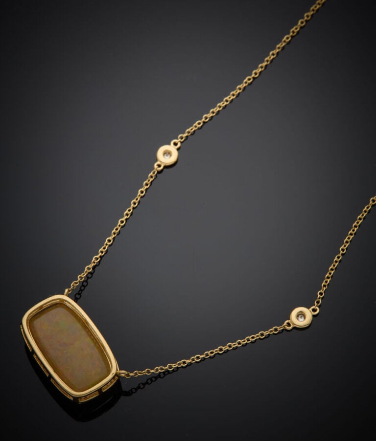 COLLIER en or jaune (750‰) retenant une opale cabochon de forme coussin, entour…