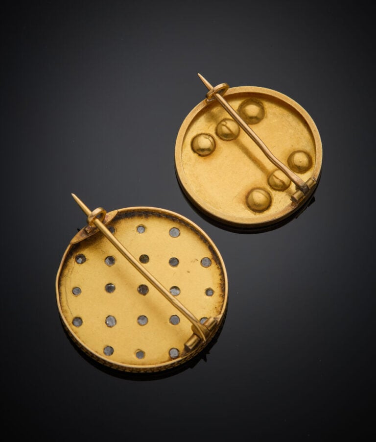 Deux BROCHES circulaires en or jaune (750‰) flanqué de diamants taillés en rose…