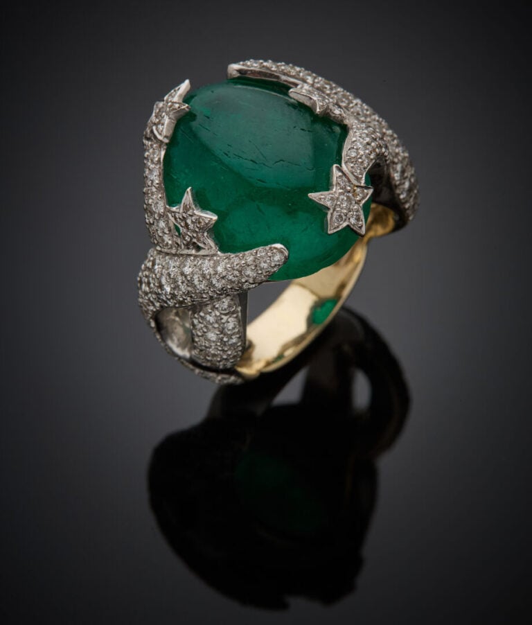Importante BAGUE "cinq étoiles" en or gris (750‰) ajouré, serti d'une émeraude…