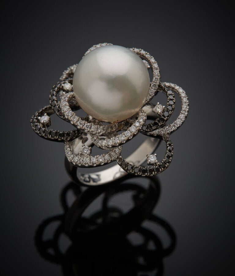 Importante BAGUE "fleur" en or gris et or noirci (750‰) ajouré, centrée d'une p…