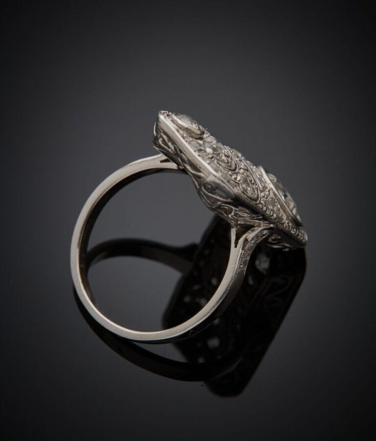 Importante BAGUE "plaque" en platine (950‰) finement ajouré à motifs de volutes…