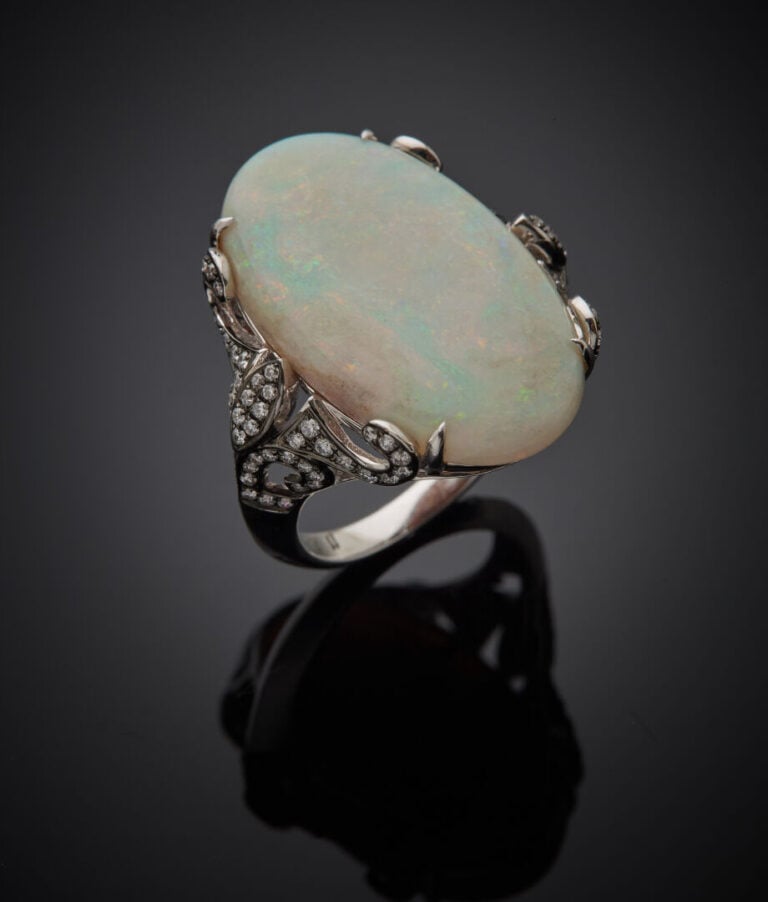 Large BAGUE en or gris et or noirci (750‰) ajouré, orné d'un opale de forme ova…