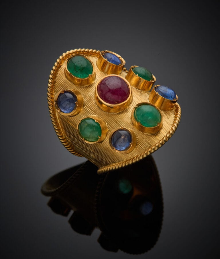 Large BAGUE en or jaune (750‰) guilloché et torsadé, orné de neuf cabochons de…