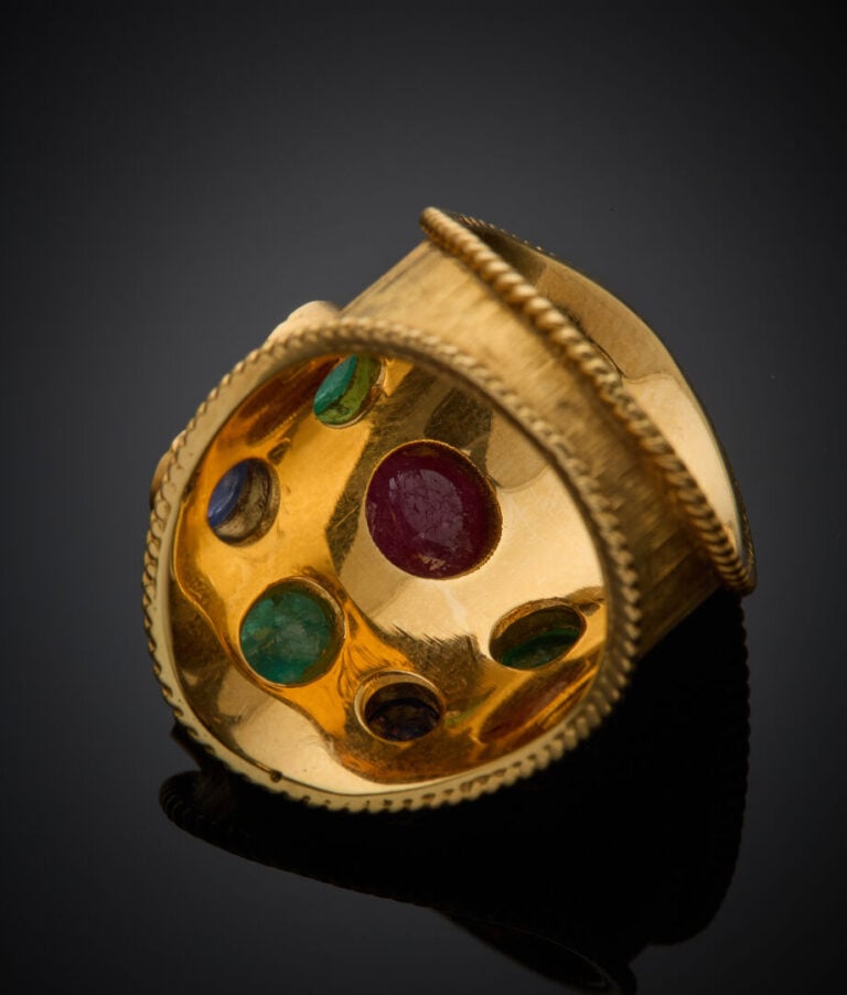 Large BAGUE en or jaune (750‰) guilloché et torsadé, orné de neuf cabochons de…
