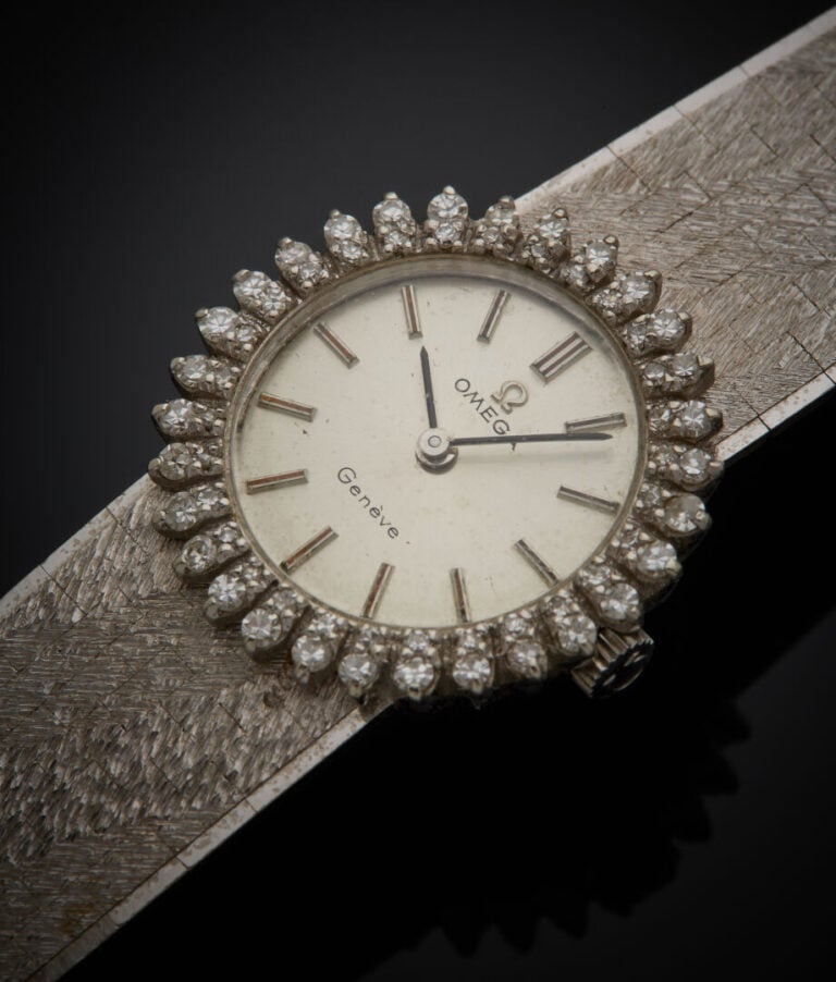 OMEGA - - BRACELET MONTRE ronde de dame en or gris (750‰). Lunette sertie de di…
