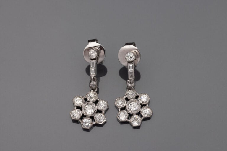 Paire de PENDANTS d'OREILLES "fleurs" en or gris (750‰) ajouré, serti de diaman…