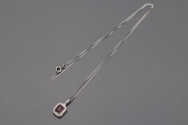 PENDENTIF et sa chaînette, en or gris (750‰) serti d'un rubis rectangulaire tai…