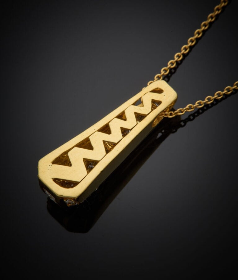 PENDENTIF "goutte stylisée" et sa CHAINETTE en or jaune (750‰) serti d'un align…