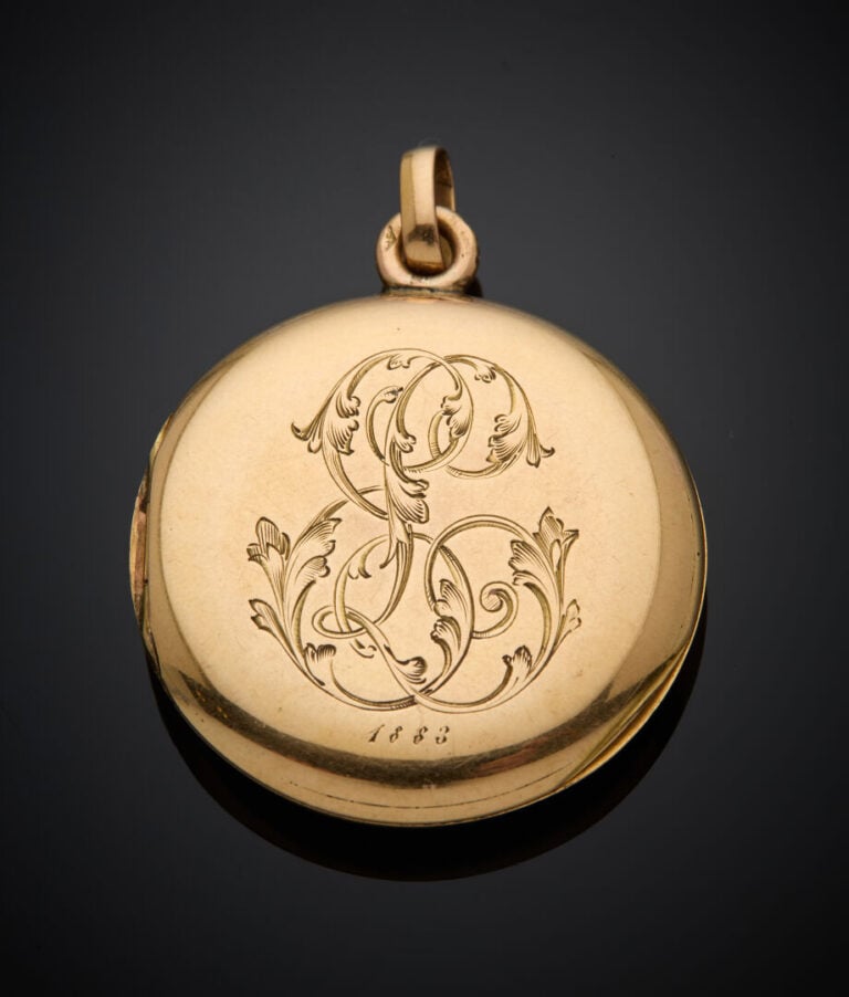 PENDENTIF "porte-souvenir" circulaire en or jaune (750‰) monogrammé, orné d'éma…